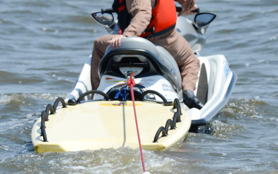 Water survival refresher trainee, Master Sgt. Joshua Mal, 3rd Airlift Squadron C-17A Globemaster III loadmaster, keeps his head above water under the supervision of Staff Sgt. Adam Ellerd, 436th Operations Support Squadron Survival, Evasion, Resistance and Escape Operations NCO in charge on Friday, July 17, 2015, near Dover Air Force Base, Del. Mal and other students had to find and release their torso harness fittings while being towed through the water to simulate being dragged by their canopy after landing in water.