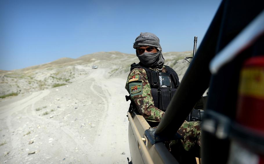 An Afghan army soldier rides in the back of a pickup truck during a convoy mission in Nangarhar province. Nangarhar is the center of the fight against the Islamic State presence, which is benefiting from rifts inside the Taliban.