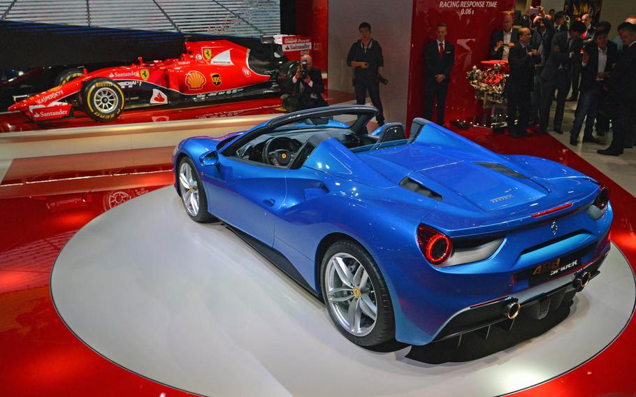 Ferrari unveild the 488 Spider at the Frankfurt International Motor Show, Tuesday, Sept. 15, 2015. Although a beautiful car, there were some comments on its color - blue rather than the popular Ferrari red. It boasts a 3.9-liter engine with 670 horsepower. In the background is a Ferrari Formula 1 racer.