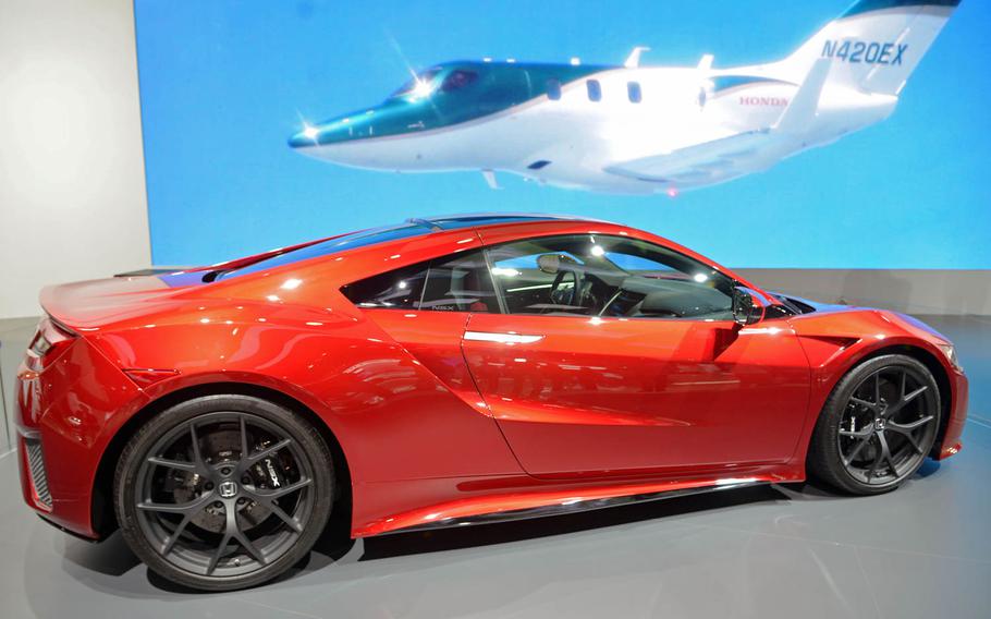 The Honda NSX - on display at Frankfurt, Germany's auto show - can't fly like the plane behind it, but it features a turbocharged V6 engine.