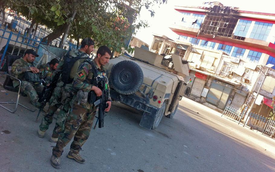 Afghan army soldiers secure a traffic circle in front of a building damaged by fighting in Kunduz city on Oct. 7, 2015. After more than a week of fighting, Afghan forces controlled some neighborhoods but continued operations to clear other areas of Taliban fighters.