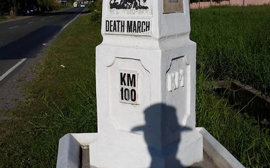 A silhouette of Tony Ahn in his boonie hat is seen as he shoots a photo of the Bataan Death March's 100-kilometer marker, Dec. 26, 2015. Ahn recently walked the route of the deadly World War II journey in which the Imperial Japanese Army transferred between 60,000 and 80,000 American and Philippine prisoners from Mariveles, Bataan, to Camp O'Donnell in Capas, Tarlac.