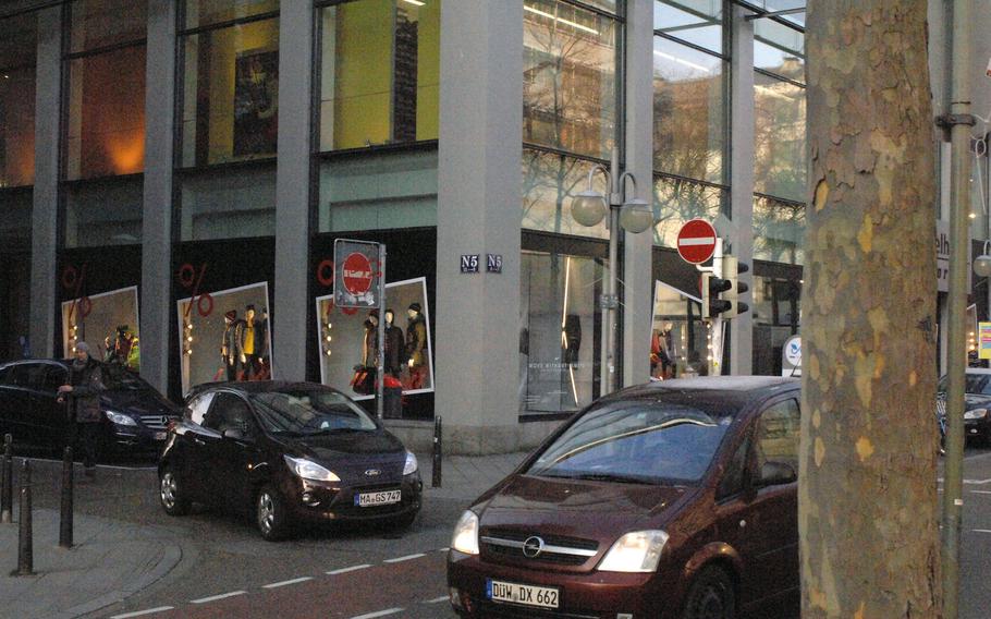 Cars and pedestrians navigate around block N5 in Mannheim, Germany. The streets in Mannheim's city center are arranged in a gridlike pattern of numbers and letters.