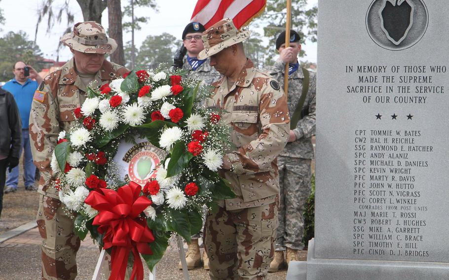 Spc. Steven R. Harrington and Pfc. Francisco Irizarry place the memorial wreath next to the Operation Desert Storm memorial, Feb. 27, during the 24th anniversary reunion held on Fort Stewart, Ga. The names of Hal Reichle and Mike Daniels, two of Fred Wellman's aviators who were killed in action, are on the monument.