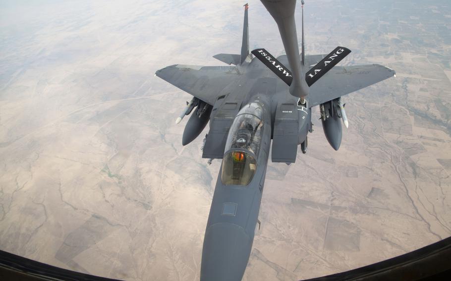 An F-15 fighter supporting airstrike operations against Islamic State militants in Iraq and Syria is refueled by a KC-135 Stratotanker in midair over Iraq on March 24, 2016.
