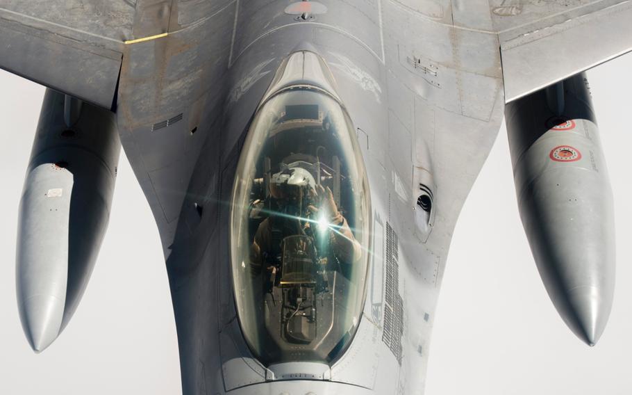 An F-16 fighter pilot supporting the air campaign against the Islamic State group in Iraq and Syria waves after his aircraft finishes refueling on March 24, 2016.