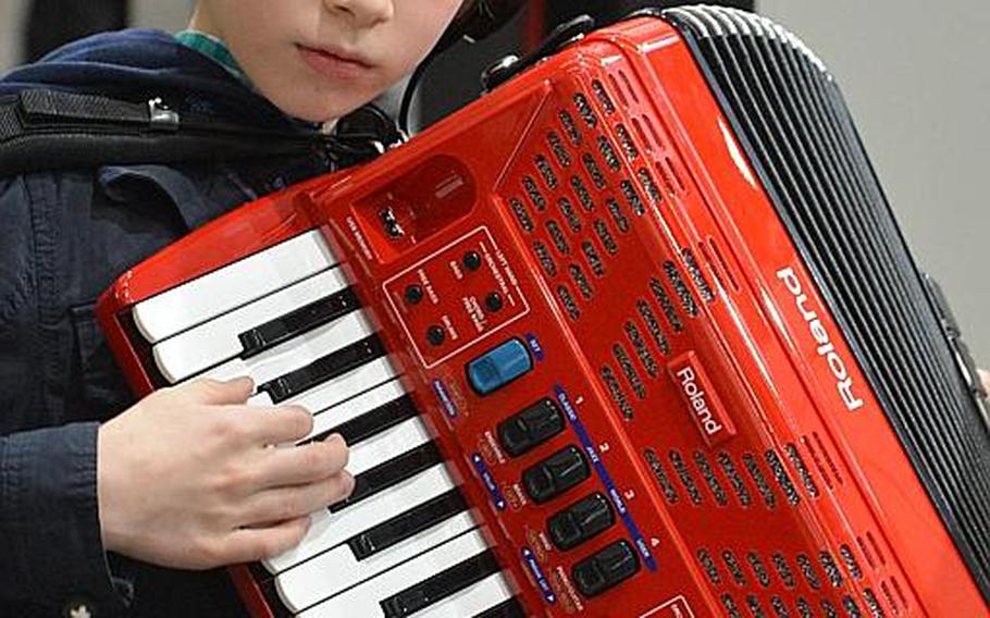 A young visitor tries out a Roland electronic accordion at the Musikmesse in Frankfurt, Germany, Thursday, April 7, 2016.