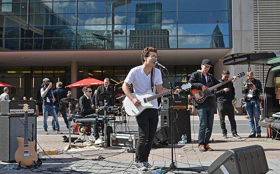 A newcomer band entertains the visitors at the Musikmesse in Frankfurt, Germany, Thursday, April 7, 2016. Reflected in the building in the background are other buildings of the Frankfurt fairgrounds where the music fair is taking place.