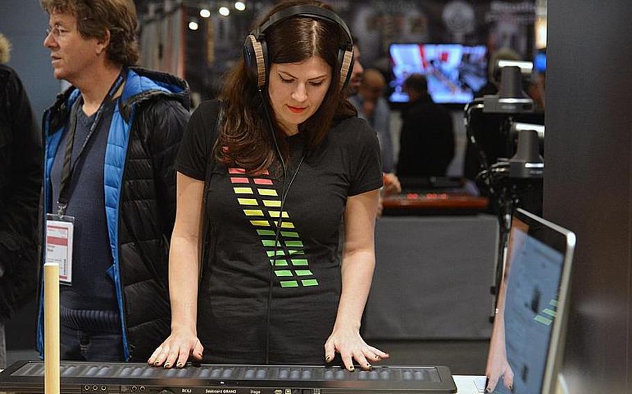 A visitor to the Musikmesse in Frankfurt, Germany, tries her hand on a Roli Seaboard Grand, Thursday, April 7, 2016. According to the company, it is a radically new musical instrument that re-imagines the piano keyboard as a soft, continuous surface.