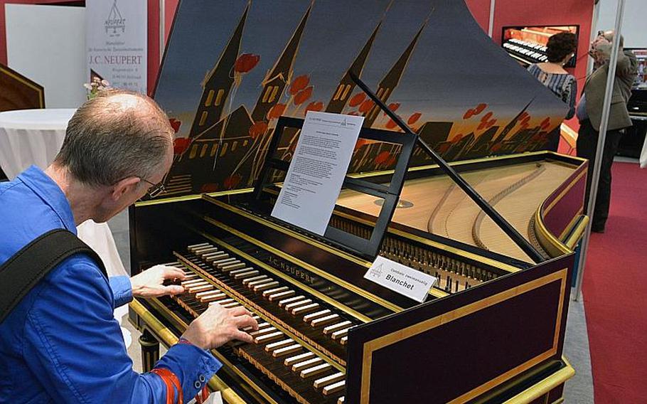 A visitor to the Musikmesse in Frankfurt, Germany, plays a interestingly decorated cembalo at the J.C. Neupert stand, Thursday, April 7, 2016.