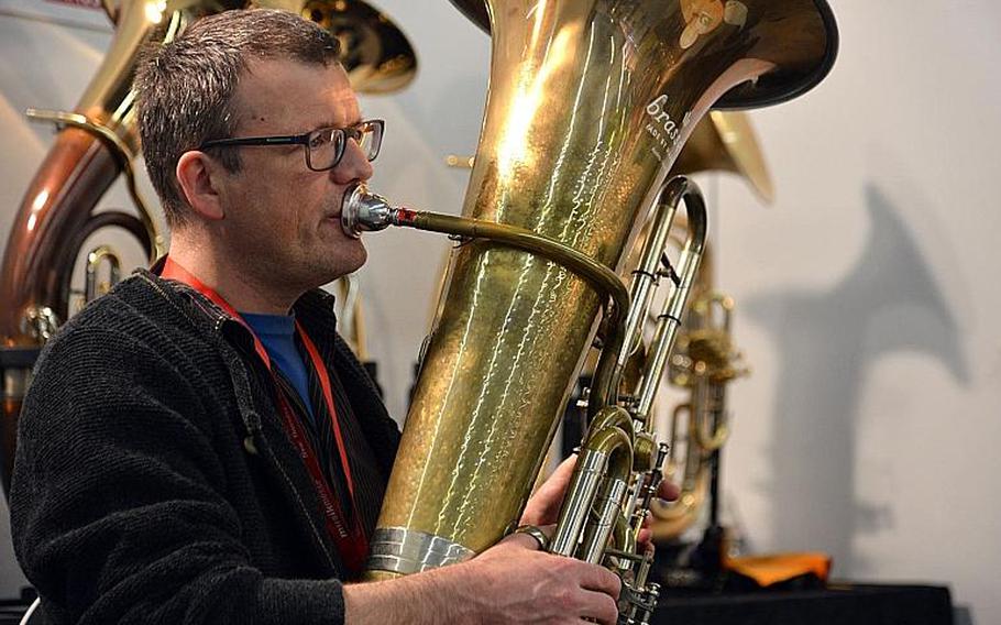 A visitor to the Musikmesse in Frankfurt, Germany, tries out a tuba at one of the stands, Thursday, April 7, 2016. Everything from musical instruments to disc jockey turntables to just about anything needed to produce digital music is on display at the music fair.