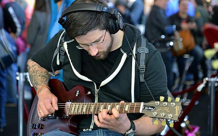 A visitor to the Musikmesse in Frankfurt, Germany, plays a Gibson Les Paul electric guitar, Thursday, April 7, 2016.