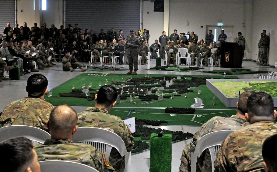 Soldiers and airmen listen to a rehearsal briefing conducted on Saturday, April 9, 2016, at Aviano Air Base, Italy. Dozens of participants detailed their parts in the Saber Junction exercise with the help of scale models of the jump zone.
