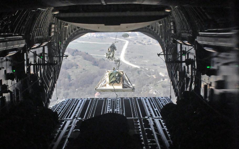 A parachute begins to deploy as a pallet loaded with equipment leaves the cargo hold of a C-17 flying over Hohenfels, Germany, on Monday, April 11, 2016, as part of exercise Saber Junction.