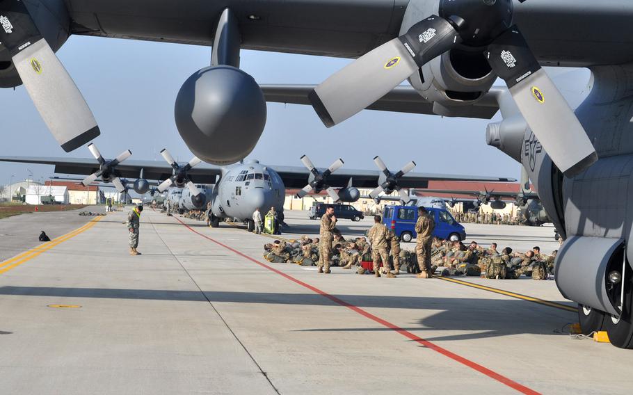 Groups of soldiers from the 173rd Airborne Brigade and allies participating in exercise Saber Junction are camped out behind C-130 transport planes parked on the south ramp at Aviano Air Base, Italy, on Tuesday, April 12, 2016.
