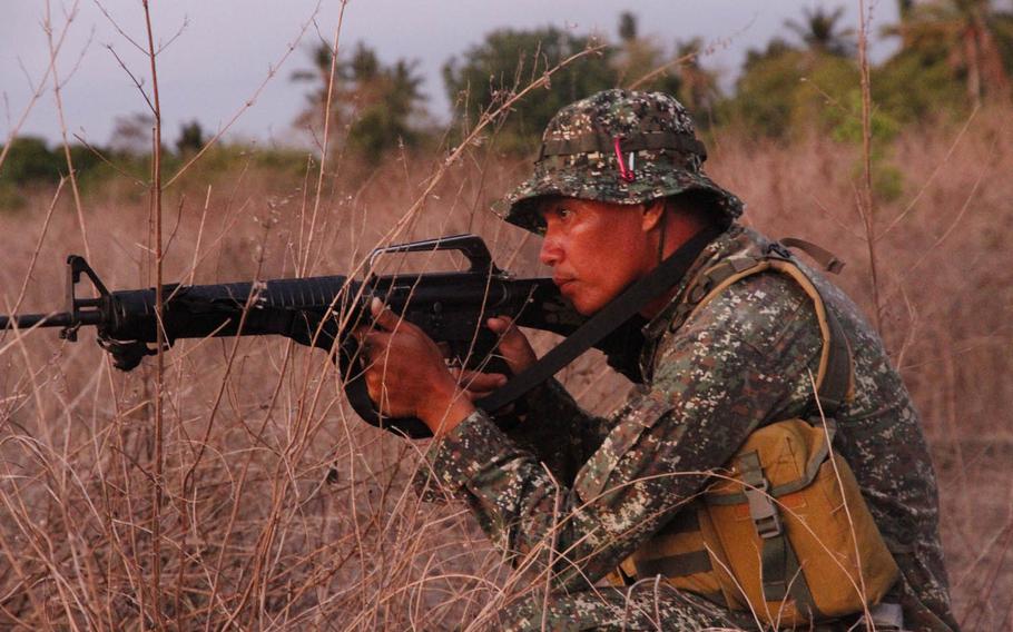 A Filipino marine guards the perimeter around an airstrip in Panay, Philippines, during Exercise Balikatan, Monday, April 11, 2016.