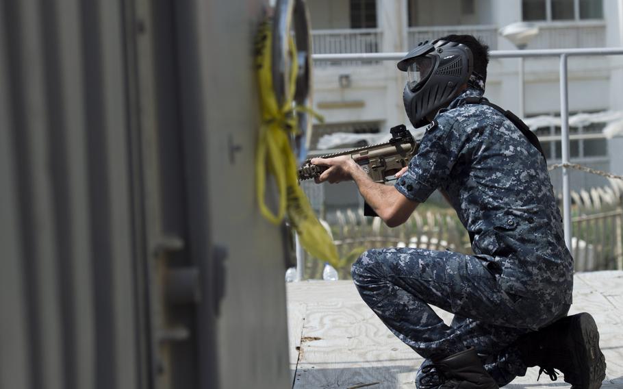 A sailor from a Bahraini Royal Navy special task force covers an angle possible combatants could attack from during a visit, board, search and seizure demonstration for the International Mine Countermeasures Exercise at Naval Support Activity Bahrain April 9, 2016.
