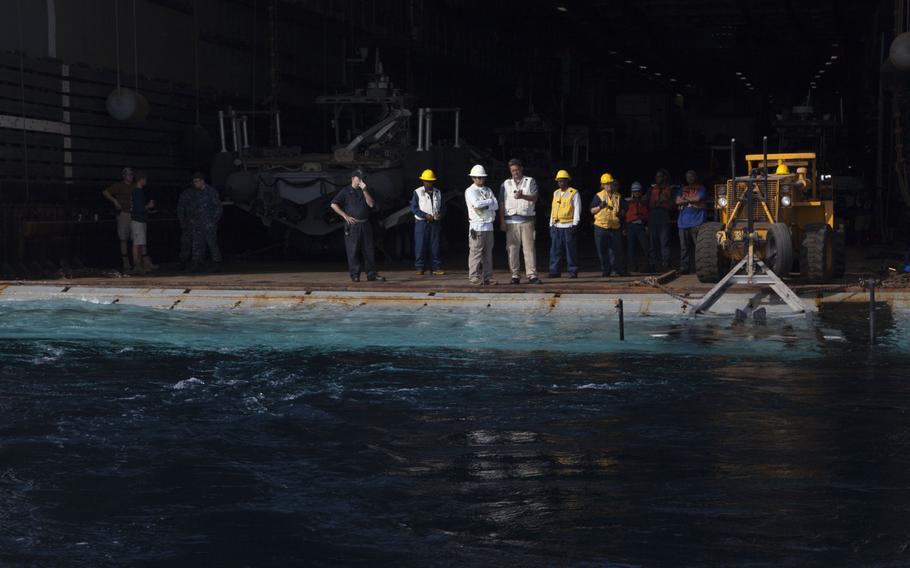 Personnel aboard the afloat forward staging base USS Ponce wait in the well deck for the arrival of a rigid-hulled inflatable boat carrying media during the International Mine Countermeasures Exercise April 10, 2016.