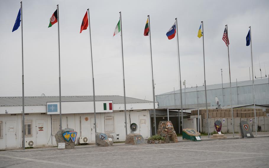 Flags representing NATO, Afghanistan, and coalition forces based at Italian-run Camp Arena in Herat province fly on April 7, 2016. Uncertainty over how long international troops will remain at the base has altered initial plans to hand over the facility to Afghans earlier this year.