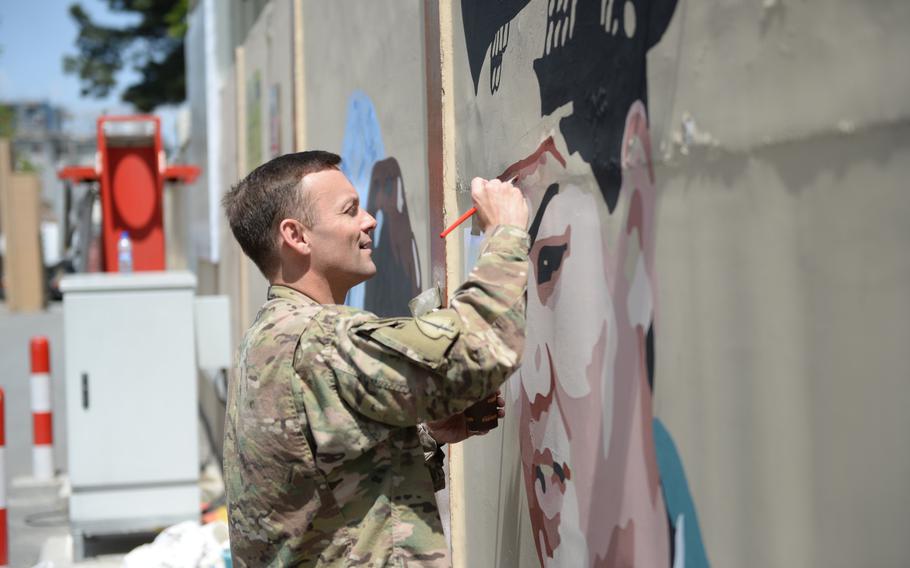 NATO spokesman Brig. Gen. Charles H. Cleveland adds his support to a mural painting at Resolute Support headquarters in Kabul on April 18, 2016.