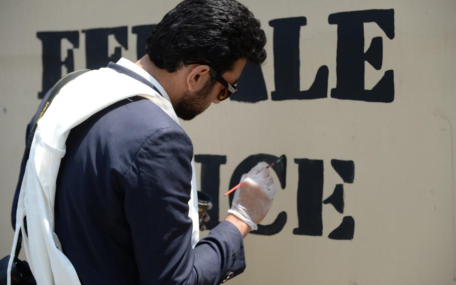 Zabiullah Modaber, a member of Art Lords, paints ''Afghan female police a force for good,'' as part of a mural at Resolute Support headquarters on April 18, 2016.