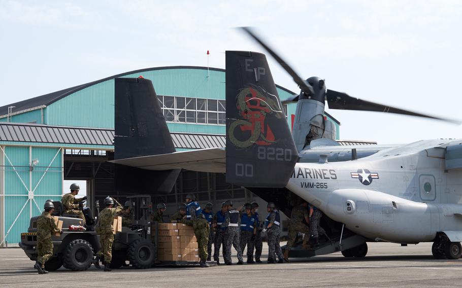Soliders and airmen from the Japan Self-Defense Force load emergency aid on to a U.S. MV-22 Osprey at Camp Takayubaru in Kumamoto, Japan, on Wednesday, April 20, 2016. Japanese and American troops delivered 18,000 pounds of relief supplies Wednesday to distribute to earthquake victims.