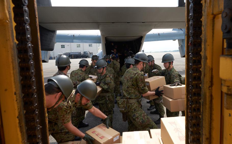 Soliders and airmen from the Japan Self-Defense Force load emergency aid on to a U.S. MV-22 Osprey at Camp Takayubaru in Kumamoto, Japan, on Wednesday, April 20, 2016. Japanese and American troops delivered 18,000 pounds of relief supplies Wednesday to distribute to earthquake victims.