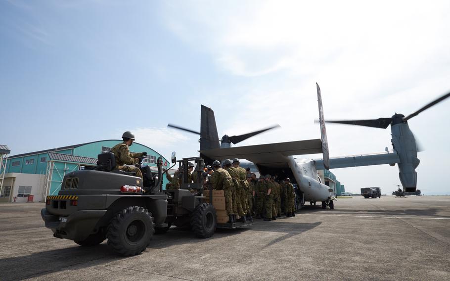 Soliders and airmen from the Japan Self-Defense Force load emergency aid on to a U.S. MV-22 Osprey at Camp Takayubaru in Kumamoto, Japan, on Wednesday, April 20, 2016. Japanese and American troops delivered 18,000 pounds of relief supplies Wednesday to distribute to earthquake victims.