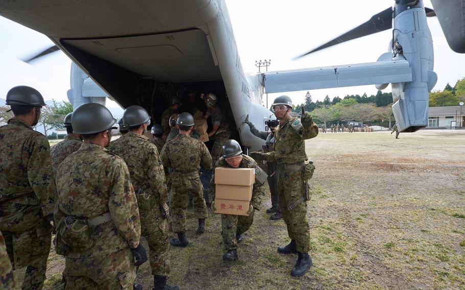Soldiers from the Japan Ground Self-Defense Force unload emergency aid off a U.S. MV-22 Osprey at Hakusui Sports Park in Kumamoto, Japan, on Wednesday, April 20, 2016. The aid will be distributed to earthquake victims in the southern Japan prefecture.
