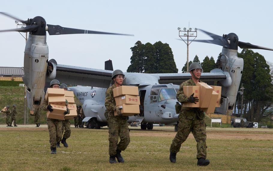 Soldiers from the Japan Ground Self-Defense Force unload emergency aid off a U.S. MV-22 Osprey at Hakusui Sports Park in Kumamoto, Japan, on Wednesday, April 20, 2016. The aid will be distributed to earthquake victims in the southern Japan prefecture.