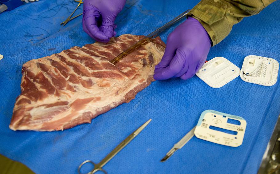 Sgt. Treall Thomas, 212th Combat Support Hospital medic, practices securing a chest tube in Miesau, Germany, on Wednesday, April 20, 2016. Medical personnel from the hospital were honing their skills prior to a mass casualty exercise for a NATO evaluation team.