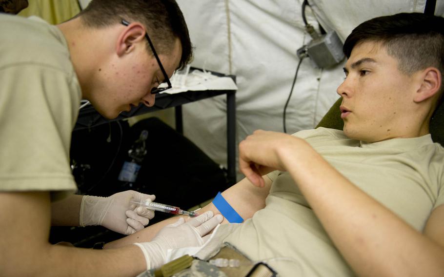 Pvt. Matthew McDaniel, left, gets advice about properly giving patients an IV from 1st Lt. Michael Menges in Miesau, Germany, on Wednesday, April 20, 2016. Both McDaniels and Menges are from the 212th Combat Support Hospital.