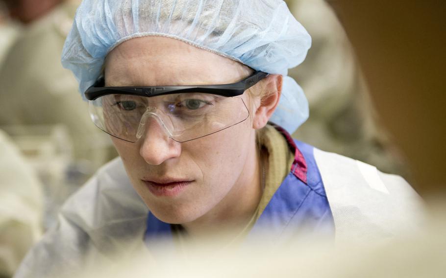Maj. Emily Hathaway, 212th Combat Support Hospital surgeon, checks a simulated patient's injuries during a mass casualty exercise in Miesau, Germany, on Wednesday, April 20, 2016.