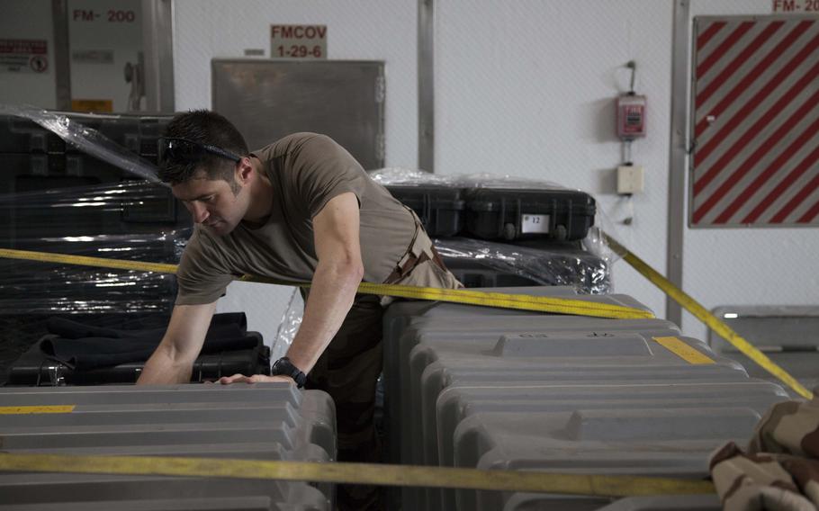 Clement Jacotot, a member of a French explosive ordnance disposal team checks gear in the well deck of the USNS Choctaw County during the International Mine Countermeasures Exercise on April 10, 2016.