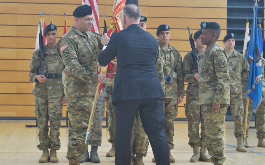 Col. Todd E. Fish, left, takes the guidon during a change of command Friday afternoon at Clay Kaserne, Wiesbaden, Germany. Outgoing commander Col. Mary L. Martin is on the right.