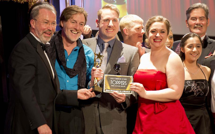 Cast members of Amelia Earhart Playhouse's performance of "The Fantasticks" accept their award for best musical ensemble during the Toppers awards in Kaiserslautern, Germany, on Saturday, April 23, 2016. David Mattingly, left, is programs manager for IMCOM-Europe Family, Morale, Welfare and Recreation.