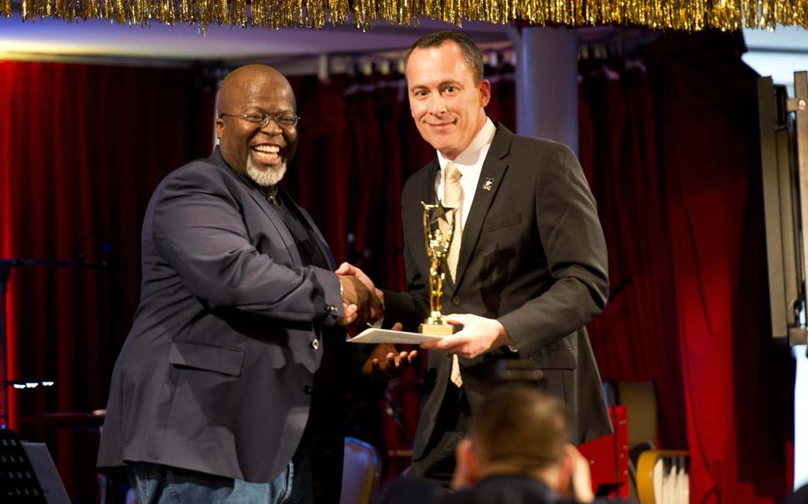 Arthur Ross Jr., left, accepts his Topper award from Steven Pelletier, U.S. Army Garrison Rheinland-Pfalz Director of Family and Morale, Welfare and Recreation, in Kaiserslautern, Germany, on Saturday, April 23, 2016. Ross won best sound design for a play and musical for his work on the SHAPE Players Performing Arts Center's production of "The Lucky Spot."
                