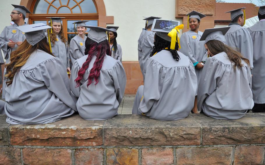 Graduates of the University of Maryland University College Europe stood in line and sat down while waiting for commencement ceremonies to start on Saturday, April 30, 2016, in Kaiserslautern, Germany. Graduates who earned associate's degrees wore the gray cap and gowns.