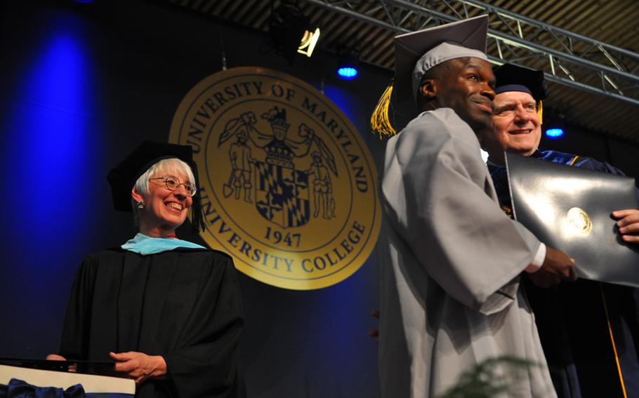 Allen Joseph Adams stands on the stage with Javier Miyares, University of Maryland University of College president, at the university's Europe division commencement ceremony on Saturday, April 30, 2016, in Kaiserslautern, Germany. Adams was one of 497 graduates to earn an associate's degree from UMUC Europe this year.
