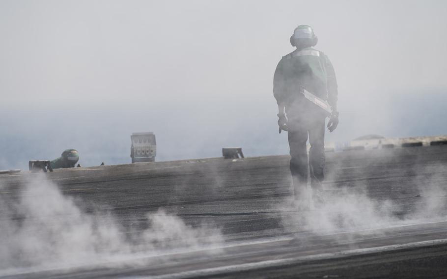 A flight deck crewmember walks along the flight deck of the aircraft carrier USS Harry S. Truman April 25, 2016. The Truman carrier strike group has been extended 30 days to support operations against terrorist networks in the Middle East including the Islamic State in Iraq and Syria.