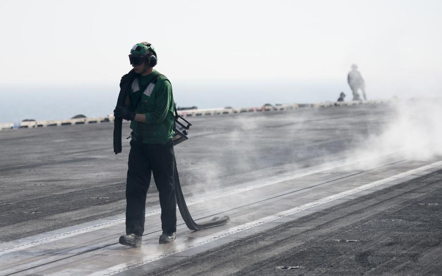 A flight deck crewmember walks along the catapult during flight operations aboard the aircraft carrier USS Harry S. Truman April 25, 2016. The Truman carrier strike group has been extended 30 days to support operations against terrorist networks in the Middle East including the Islamic State in Iraq and Syria.