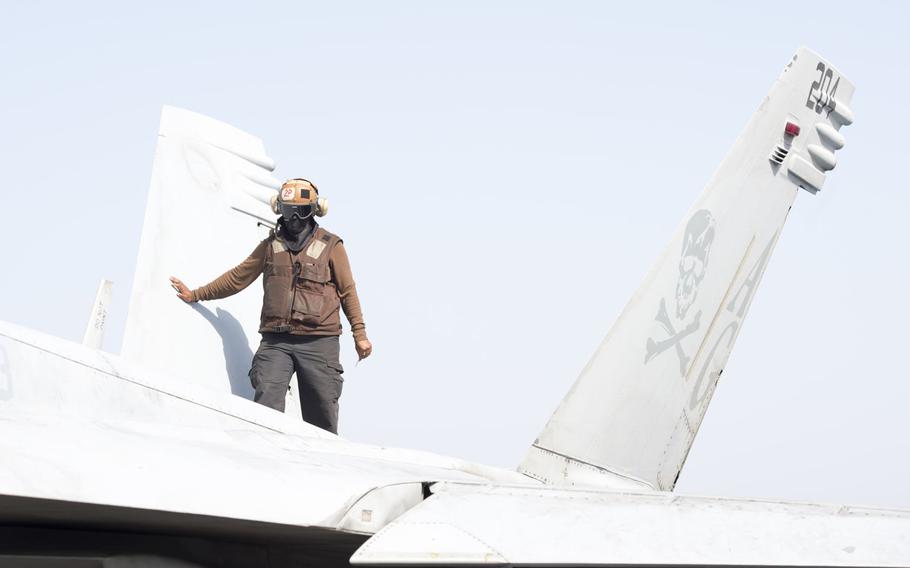 A air wing plane captain conducts a spot check on an aircraft aboard the USS Harry S. Truman April 26, 2016.