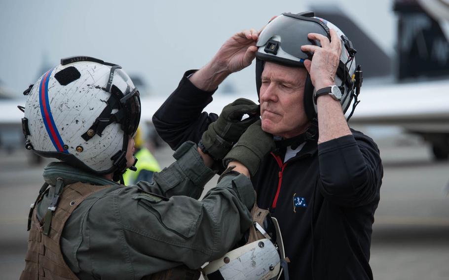 An crewmember from the Golden Falcons of Helicopter Sea Combat Squadron 12 helps Secretary of the Navy Ray Mabus with his helmet before the secretary boards an MH-60 Seahawk helicopter at Naval Air Facility Atsugi, Japan, Friday, May 6, 2016. Mabus stopped briefly at Atsugi en route to Tokyo for meetings with senior Japanese defense officials.