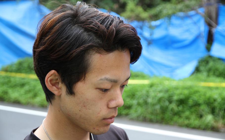 Kakeru Miyagi, 20, of Nago prays for the soul of his former classmate Rina Shimabukuro at the site in Onna Village's Afuso district where police found her body Thursday. A former U.S. Marine has admitted to killing the 20-year-old office worker.