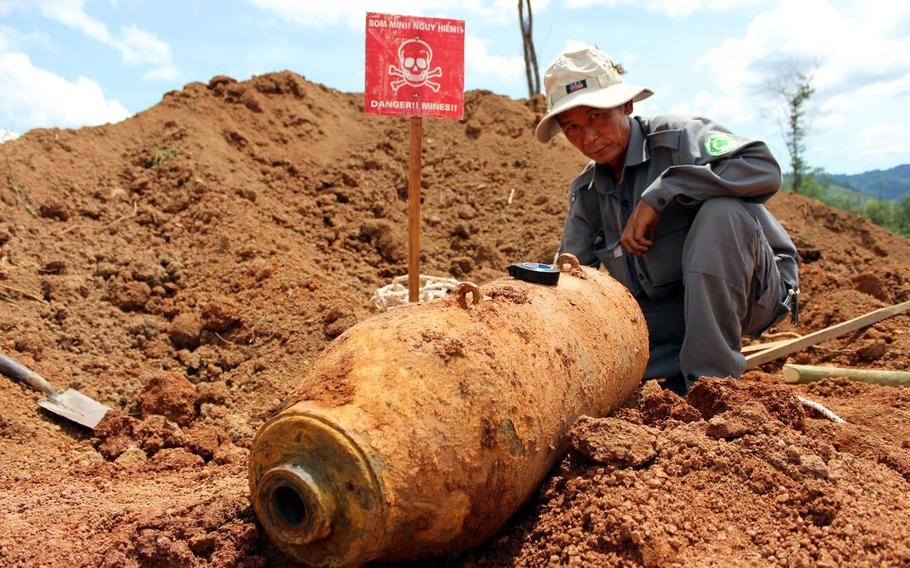 National technical officer Bui Trong Hong, working with Project RENEW, investigates the condition of a 250-pound U.S. aerial bomb found last June five feet underground at a construction site in Quang Tri Province, Vietnam.