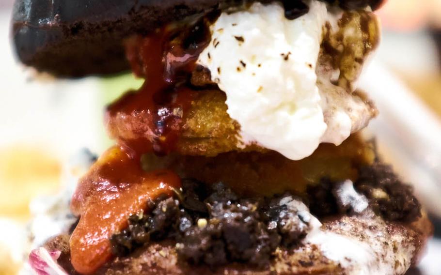The G.B. Burger is J.S. Burgers Cafe "Ghostbusters"-inspired black-bunned burger topped with tapenade, cream, onion rings and a "bloody hell" ketchup. The ketchup comes in three spice variants, and the bun gets its color and slight bitterness from the infused squid ink.
