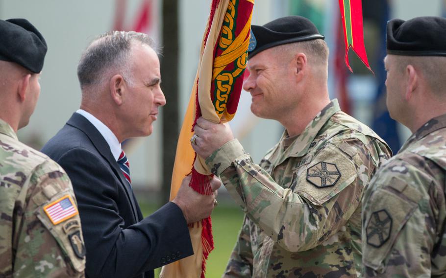 Michael Formica, left, director of Installation Management Command Europe, hands off the guidon to U.S. Army Garrison Bavaria's newest commander, Col. Lance Varney, during an assumption-of-command ceremony in Grafenwoehr, Germany, on Tuesday, July 5, 2016.