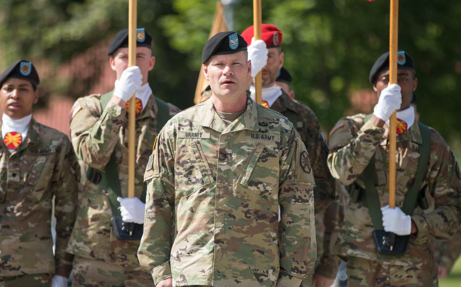 Col. Lance Varney stands in front of the color guard during his assumption of command ceremony at Grafenwoehr, Germany, on Tuesday, July 5, 2016, as U.S. Army Garrison Bavaria's newest commander.