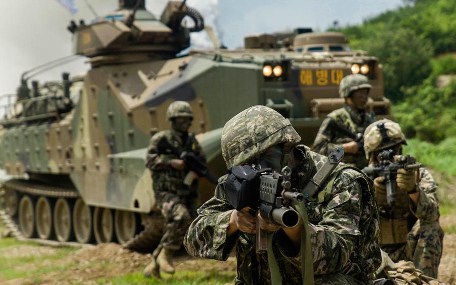 A Republic of Korea Marine sights in alongside U.S. Marines as ROK Assault Amphibious Vehicles shoot off smoke behind them July 6, 2016 at Suseong Range, South Korea, during a Korean Marine Exchange Program. The goal of the KMEP is to sustain the combined force and enhance the ROK-U.S. team at the tactical level to build combined war fighting capabilities. During this exercise, the Marines carried out a bilateral regimental-sized Marine Air Ground Task Force operation for the first time. The ROK Marines were a part of 73rd Battalion, 7th Regiment, 1st Marine Division. The U.S. service members are a part of 2nd platoon, Fox Company, 2nd Battalion, 2nd Marine Regiment, currently attached to 4th Marine Regiment, III Marine Expeditionary Force through the unit deployment program. (U.S. Marine Corps photo by Lance Cpl. / Released)