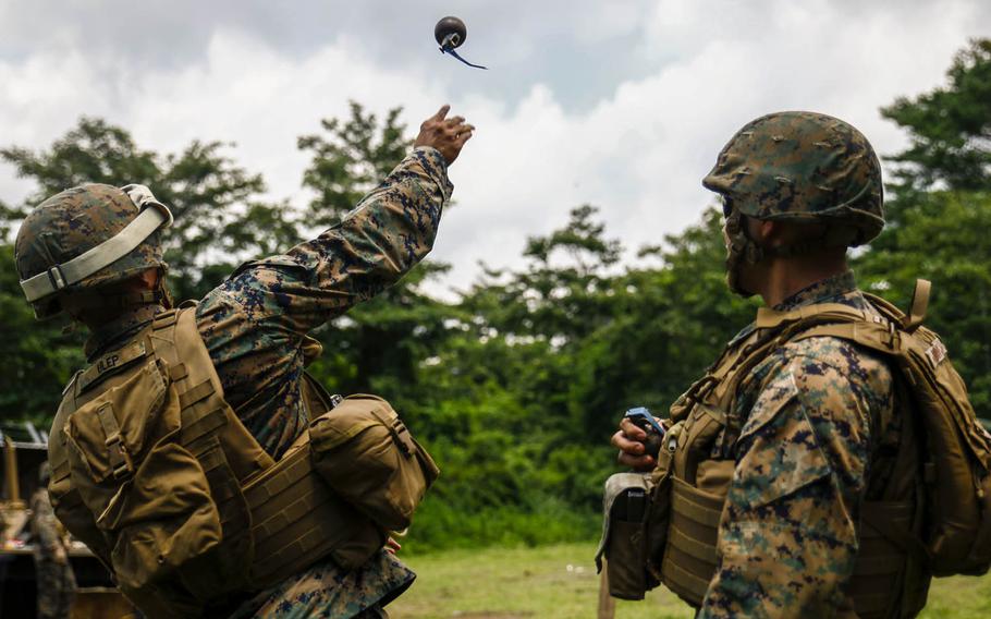 Lance Cpl. Jordan Ulep, left, a heavy equipment operator with Marine Wing Support Squadron 171 stationed at Marine Corps Air Station Iwakuni, Japan, throws an M69 practice grenade during Eagle Wrath 2016 at Combined Arms Training Center Camp Fuji, Monday, July 11, 2016.